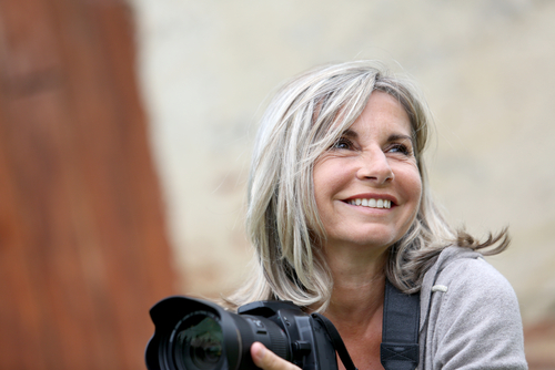 Senior woman photographing landscape, capturing moments with precise vision