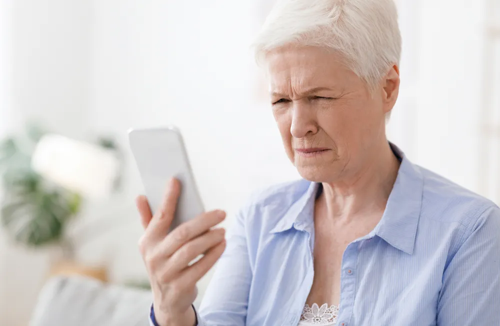 Elderly woman reading book comfortably – enjoying clear vision after cataract surgery
